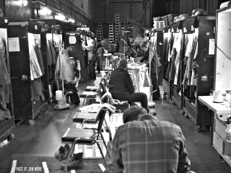 A crew of about eight costumers iron, steam, clean and repair costumes backstage at the Buell Theatre. Photo by John Moore.  