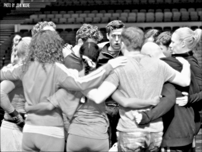 The cast circles up for a vocal warmup onstage at the Buell Theatre moments before the audience is allowed in. Photo by John Moore.  